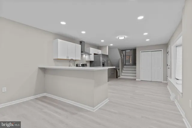 a view of kitchen with kitchen island a sink wooden floor and center island