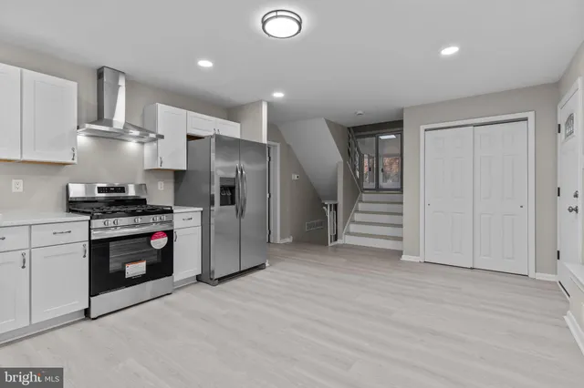 a kitchen with stainless steel appliances granite countertop a refrigerator a stove and a sink