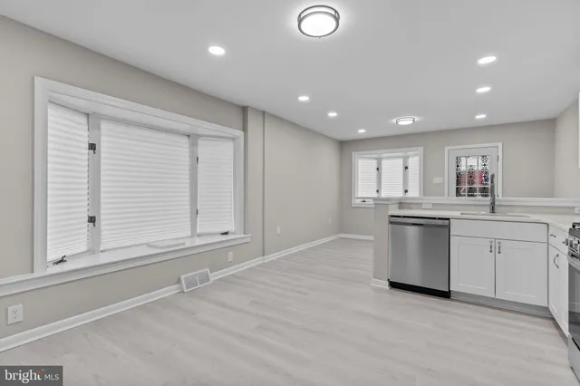 a kitchen with white cabinets and sink