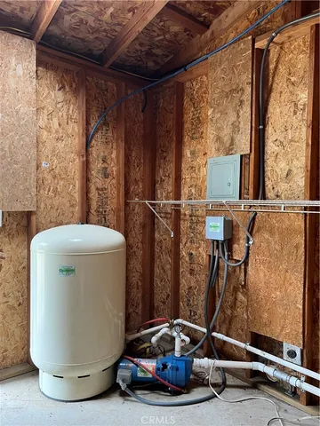 a view of a room with water heater and wooden door