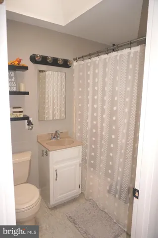 a bathroom with a toilet and a shower curtain