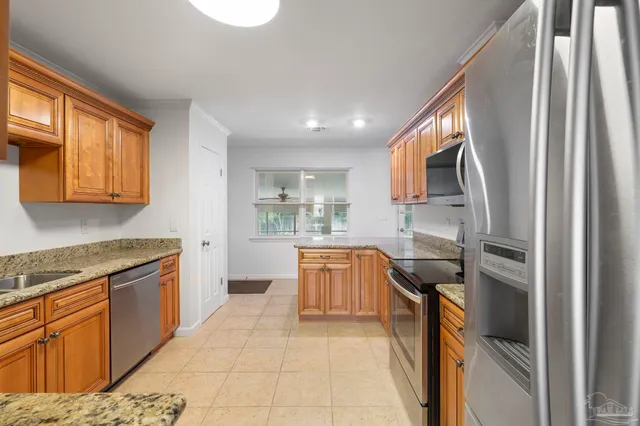 a kitchen with stainless steel appliances granite countertop a stove top oven sink and cabinets