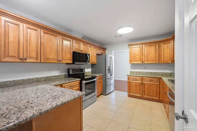 a kitchen with granite countertop stainless steel appliances a stove sink and microwave