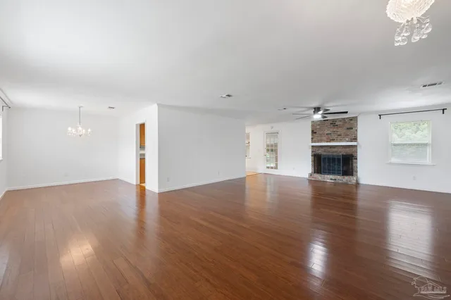 a view of empty room with wooden floor and fireplace