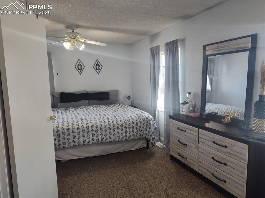 37 Massari Road Pueblo, CO 81001 - Photo 15 of 37 a bedroom with a large bed and chandelier