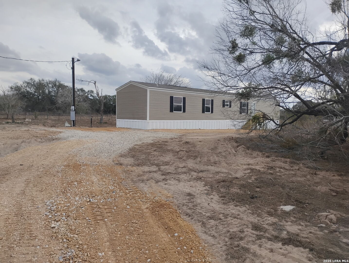 1390 Rendon Road Poteet, TX 78065 - Photo 2 of 22 a view of a yard in front of a house