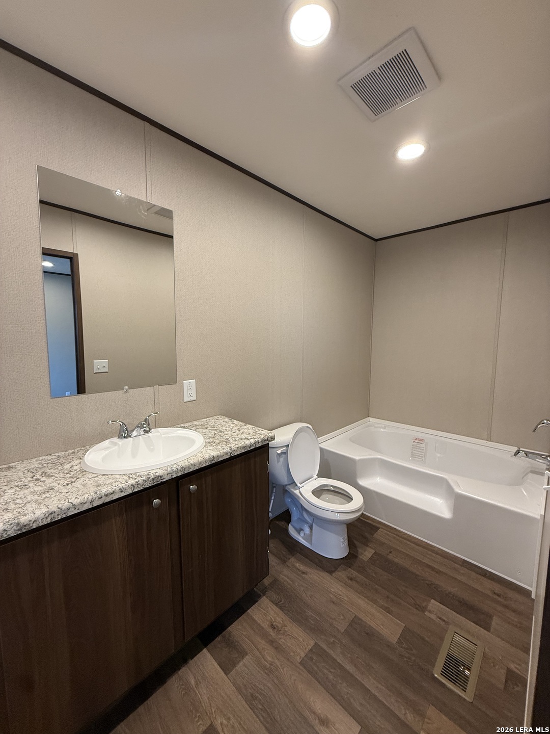 1390 Rendon Road Poteet, TX 78065 - Photo 21 of 22 a bathroom with a granite countertop sink and a mirror
