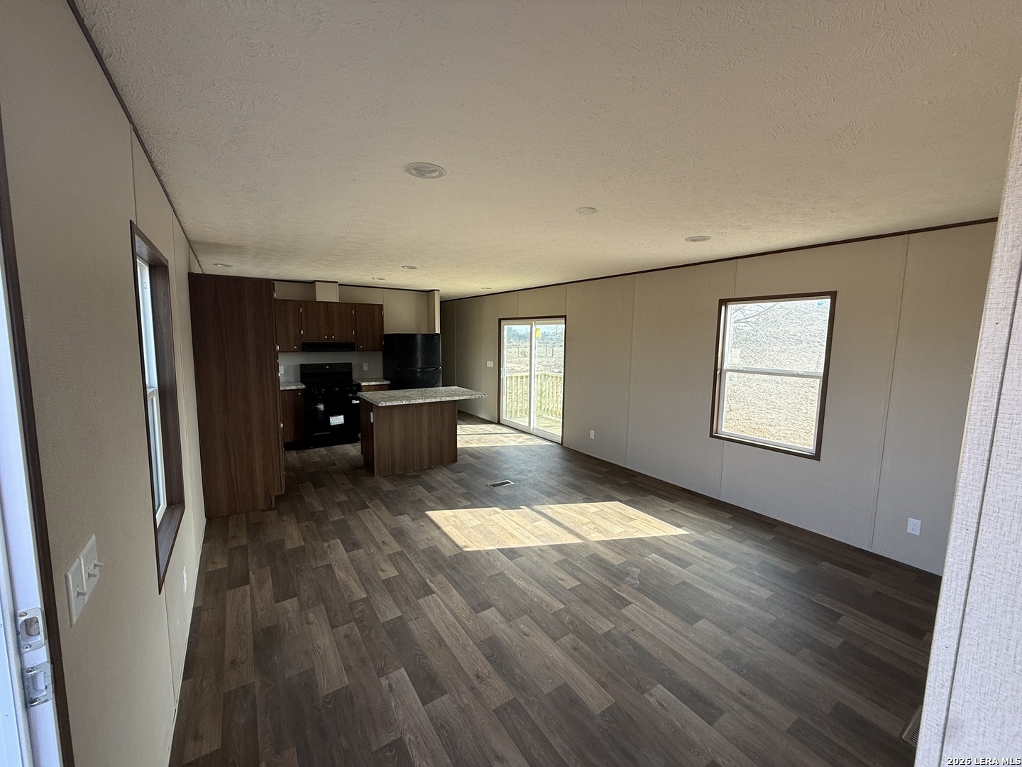 1390 Rendon Road Poteet, TX 78065 - Photo 3 of 22 a view of a room with wooden floor furniture and windows
