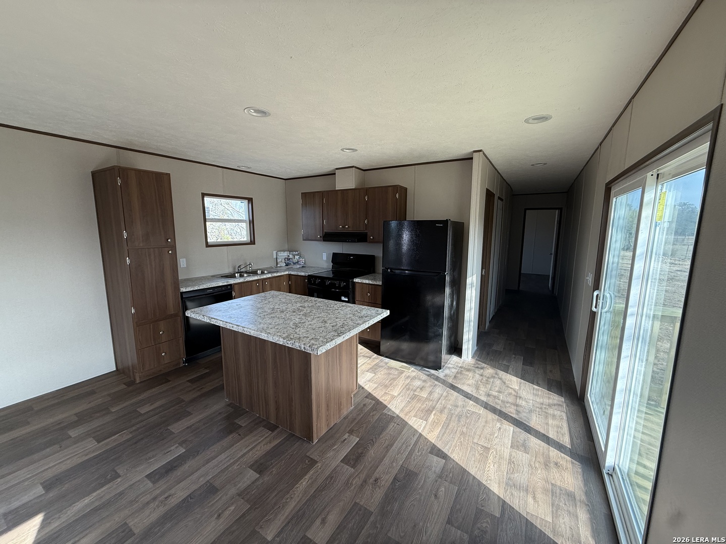 1390 Rendon Road Poteet, TX 78065 - Photo 5 of 22 a kitchen with kitchen island a counter top space a sink and a refrigerator