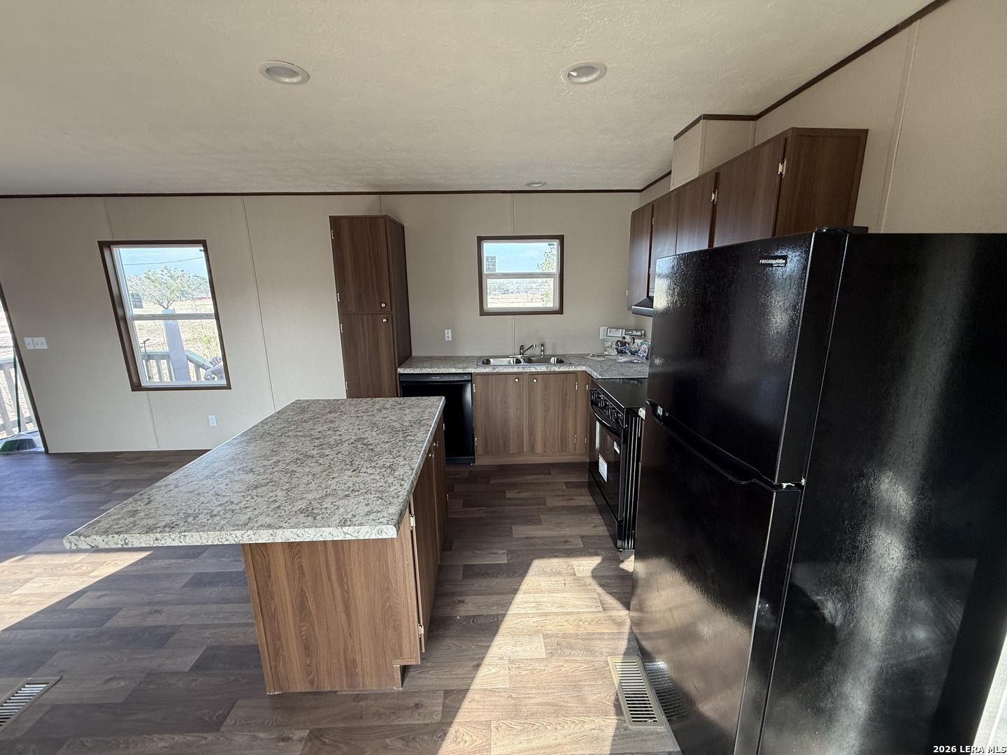 1390 Rendon Road Poteet, TX 78065 - Photo 6 of 22 a kitchen with stainless steel appliances granite countertop a refrigerator a sink a stove and island