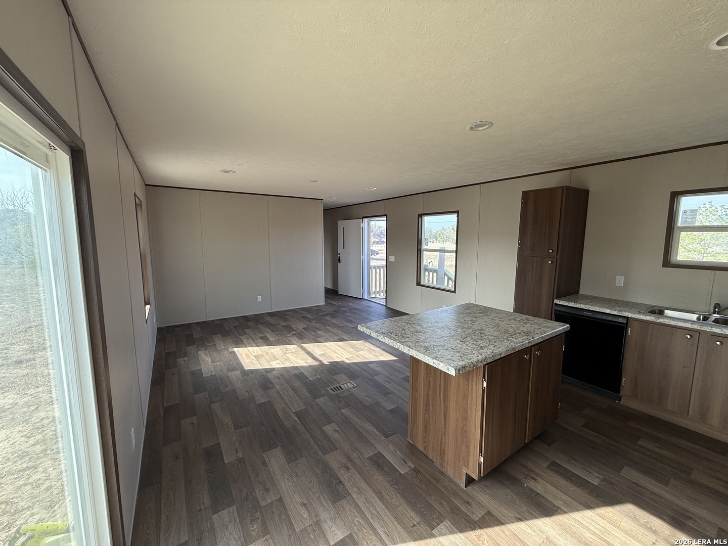 1390 Rendon Road Poteet, TX 78065 - Photo 7 of 22 an empty room with wooden floor and windows