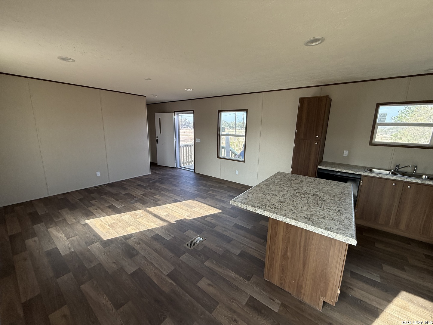 1390 Rendon Road Poteet, TX 78065 - Photo 8 of 22 an empty room with wooden floor and windows