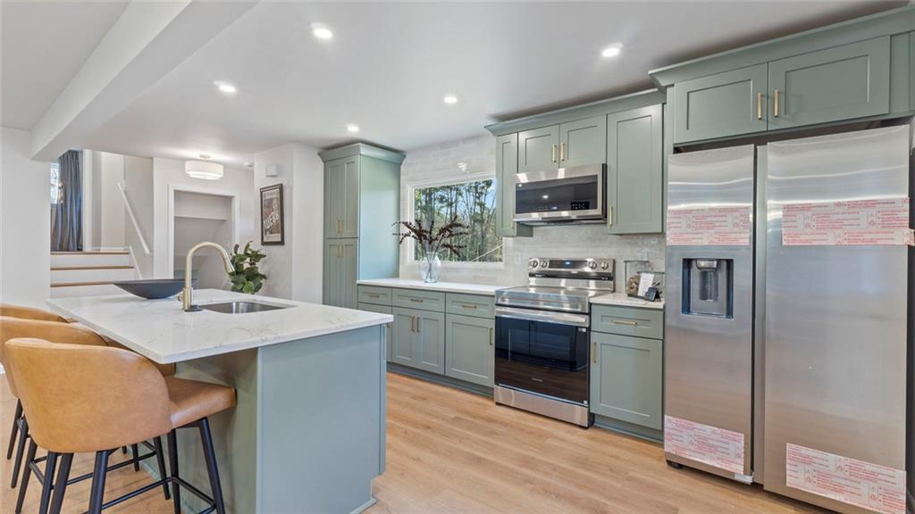 4088 Vale Court Decatur, GA 30035 - Photo 8 of 30 a kitchen with stainless steel appliances granite countertop a kitchen island hardwood floor sink stove and refrigerator
