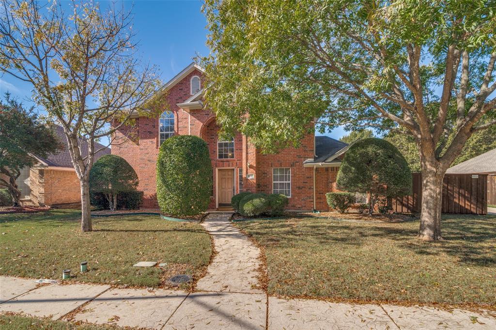 Traditional-style home with a front yard and brick siding