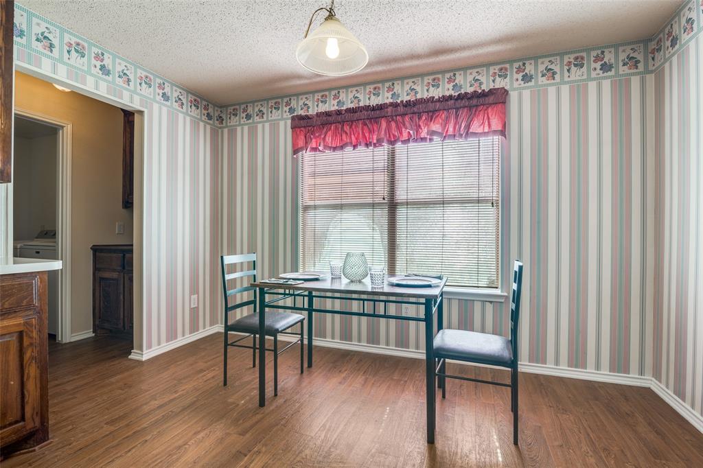 1202 Morrow Lane Allen, TX 75002 - Photo 13 of 35 Dining space featuring dark wood-type flooring, a textured ceiling, and wallpapered walls
