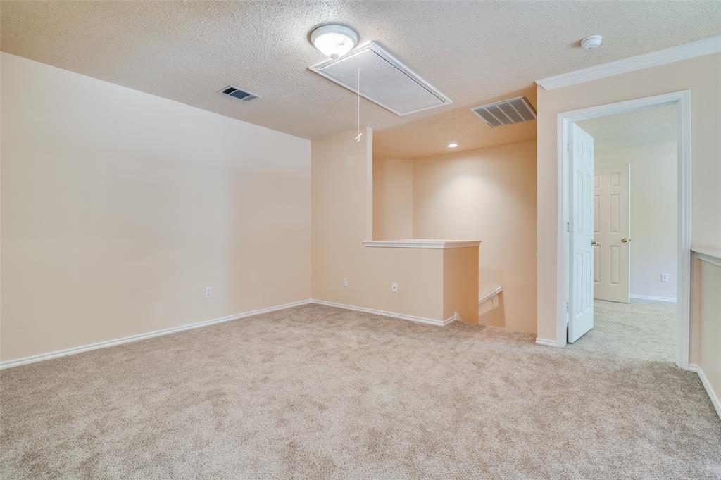 1202 Morrow Lane Allen, TX 75002 - Photo 23 of 35 Spare room featuring attic access, light carpet, and a textured ceiling