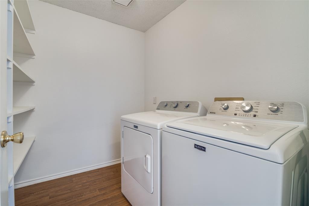 1202 Morrow Lane Allen, TX 75002 - Photo 25 of 35 Washroom with dark wood finished floors, washer and clothes dryer, and a textured ceiling