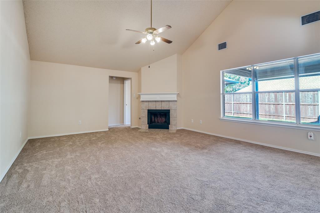 1202 Morrow Lane Allen, TX 75002 - Photo 7 of 35 Unfurnished living room featuring a fireplace, a ceiling fan, high vaulted ceiling, and light colored carpet