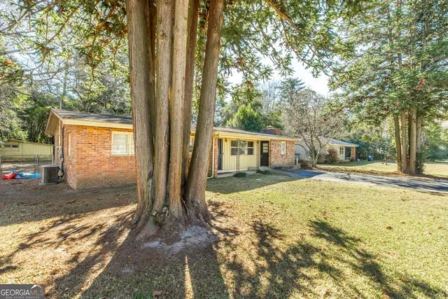 a view of a house with backyard and tree