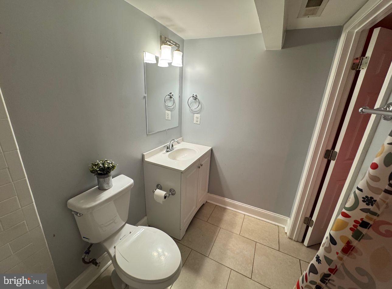 4818 Sheriff Road Northeast Washington, DC 20019 - Photo 25 of 36 a white toilet sitting next to a bathroom sink and a mirror