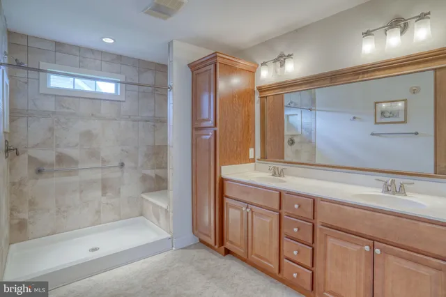 a bathroom with a granite countertop sink mirror and shower