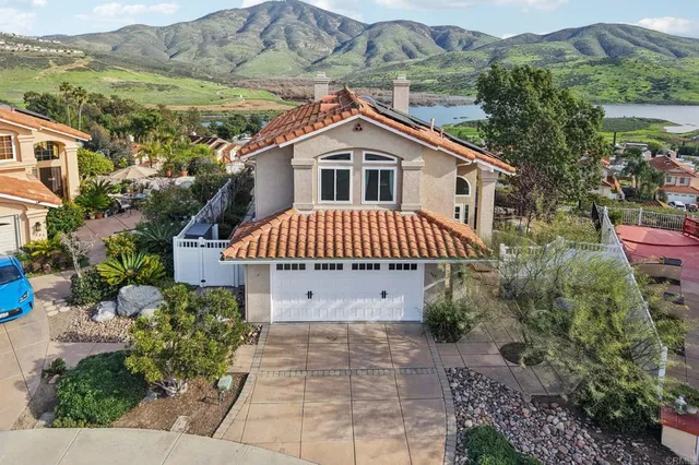 a view of a house with a yard and potted plants