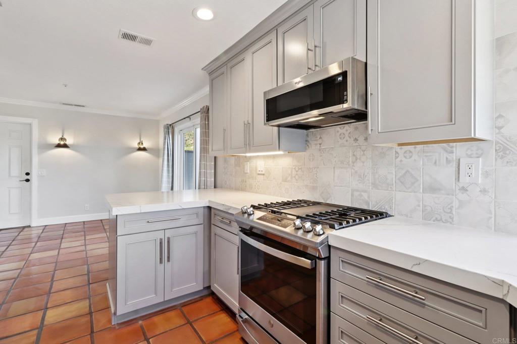 9863 Avenida Colino Spring Valley, CA 91977 - Photo 12 of 54 a kitchen with stainless steel appliances a sink a stove and cabinets