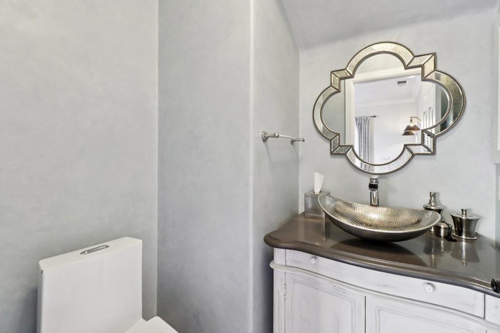 9863 Avenida Colino Spring Valley, CA 91977 - Photo 13 of 54 a bathroom with a granite countertop toilet sink and mirror