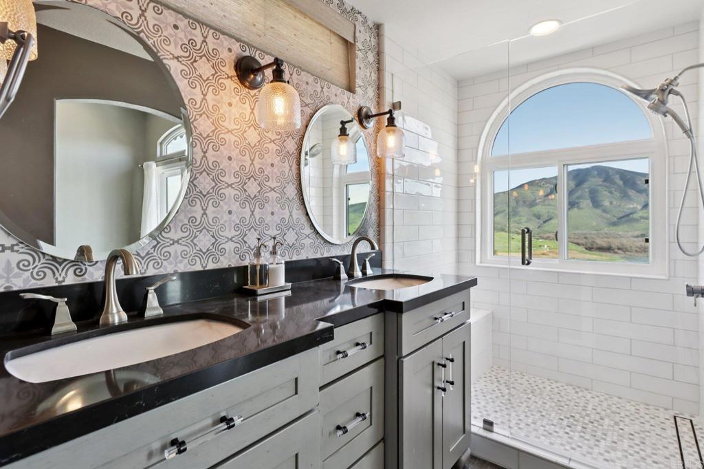 9863 Avenida Colino Spring Valley, CA 91977 - Photo 21 of 54 a bathroom with a granite countertop double vanity sink and mirror