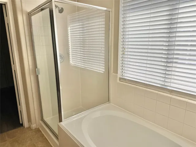 a bathroom with a bathtub and next to a window