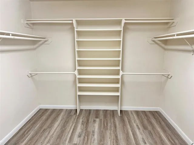 a view of walk in closet with empty racks