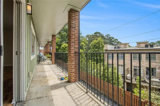 a view of a balcony with wooden floor and fence
