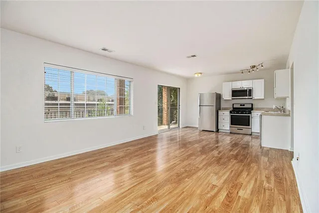 a view of kitchen with stainless steel appliances kitchen island wooden floor and window