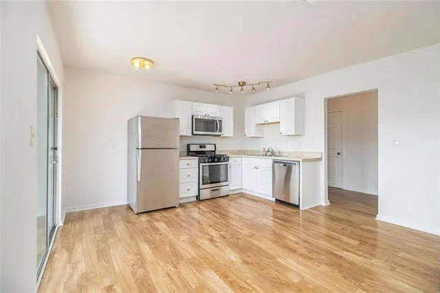 a kitchen with stainless steel appliances a refrigerator and a stove top oven