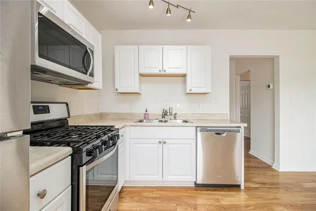 a kitchen with stainless steel appliances granite countertop a sink stove and microwave