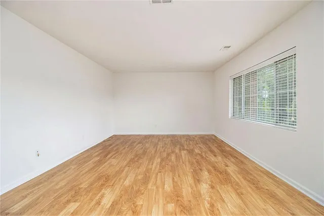 a view of empty room with wooden floor