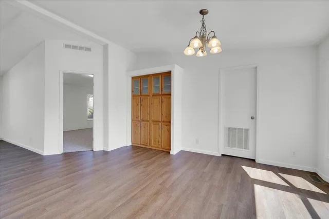 a view of an empty room with a window and kitchen view