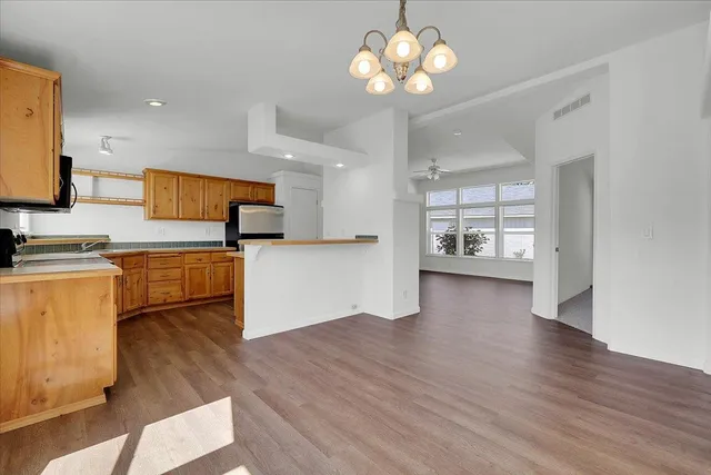a view of a kitchen with a sink a refrigerator and a stove top oven