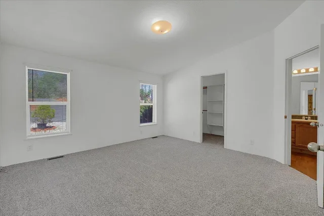 an empty room with windows and closet