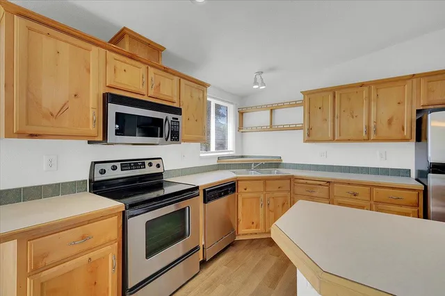 a kitchen with stainless steel appliances a stove a microwave sink and cabinets