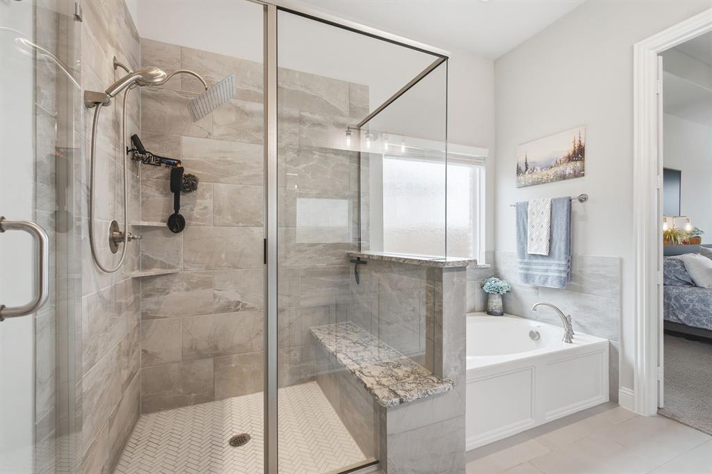 313 Tate Lane Anna, TX 75409 - Photo 15 of 30 Walk-in shower with clear glass enclosure, large format tile walls, and a herringbone tile floor
