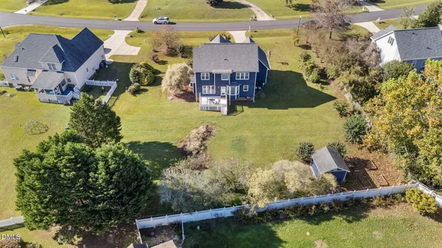 an aerial view of a house with a yard and lake view