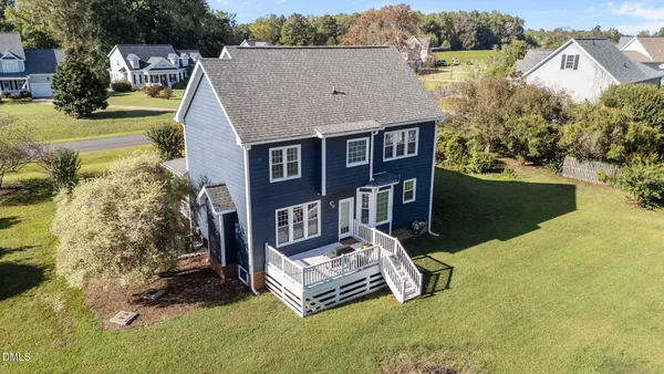 an aerial view of a house with swimming pool and a yard