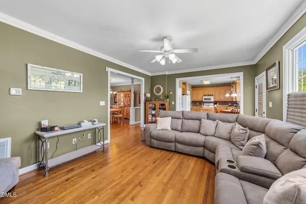 a view of a dining room with furniture a chandelier and wooden floor