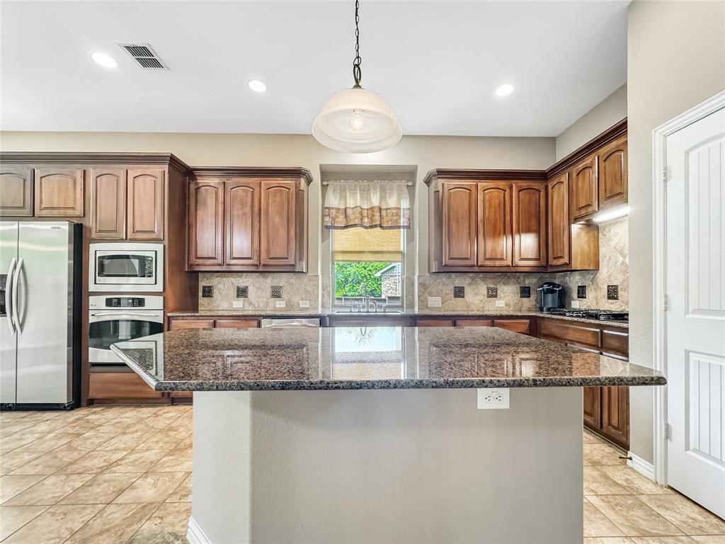 401 Varnum Way Fairview, TX 75069 - Photo 10 of 33 a kitchen with stainless steel appliances granite countertop a stove sink and cabinets