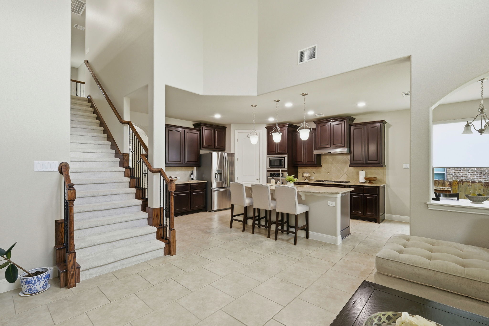110 Dasher Drive Cedar Park, TX 78613 - Photo 9 of 39 A spacious, open-concept living area features a grand staircase and a contemporary kitchen with a central island.
