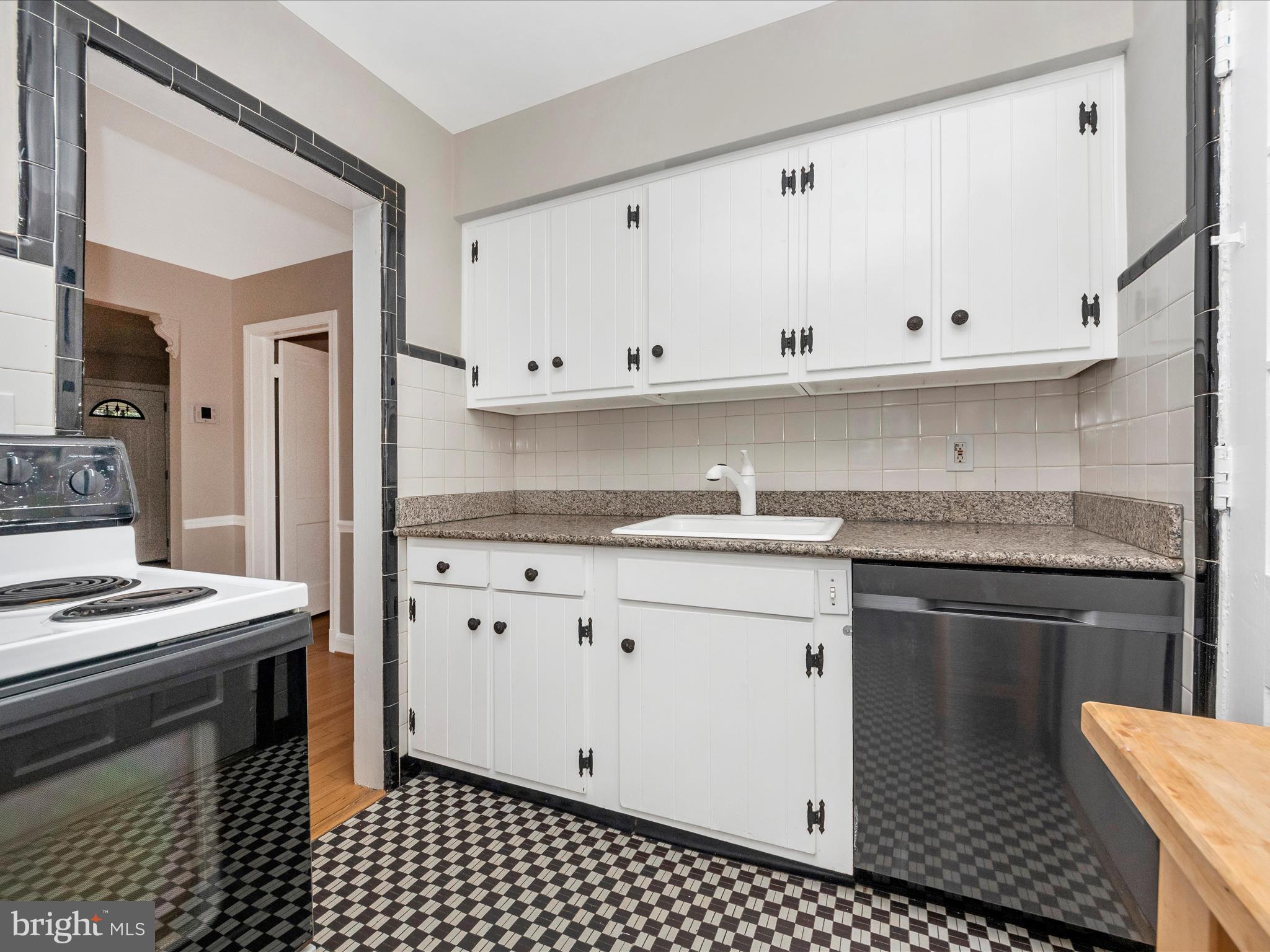 9905 Portland Road Silver Spring, MD 20901 - Photo 12 of 52 a kitchen with granite countertop a sink stove and cabinets