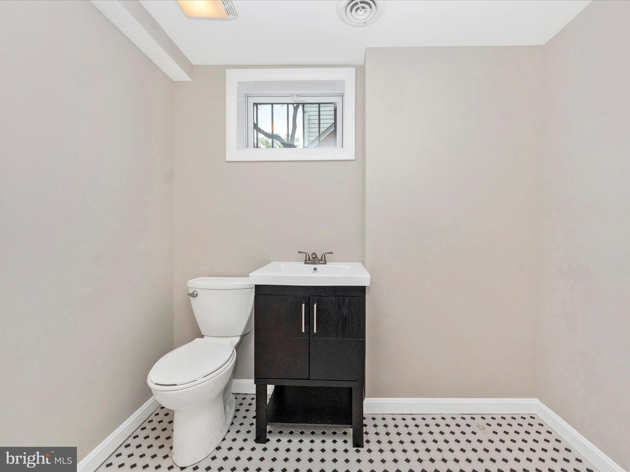 9905 Portland Road Silver Spring, MD 20901 - Photo 38 of 52 a bathroom with a toilet a sink and a window