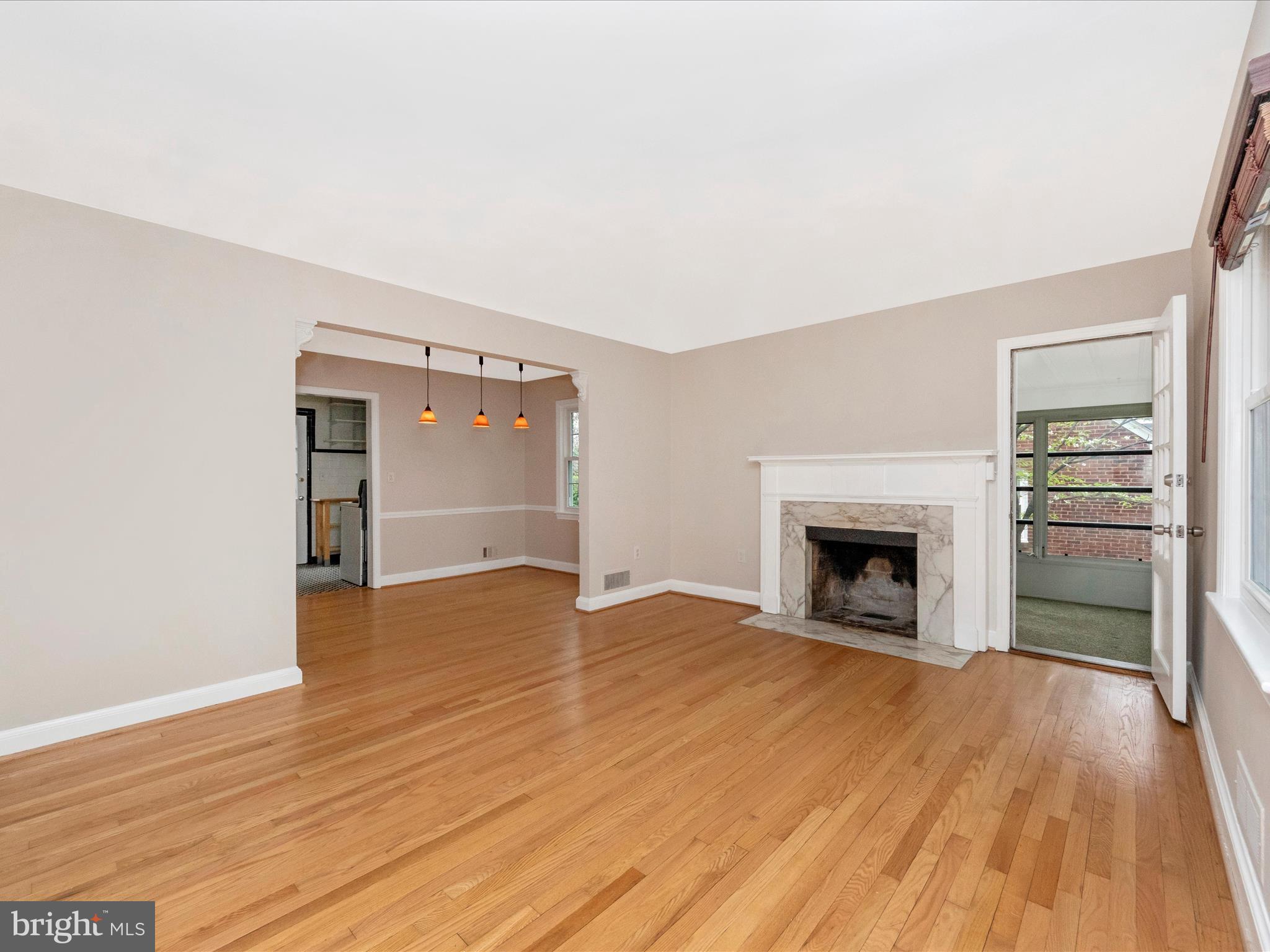 9905 Portland Road Silver Spring, MD 20901 - Photo 4 of 52 an empty room with wooden floor fireplace and windows