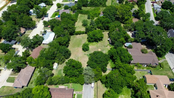 an aerial view of residential house with outdoor space and trees all around
